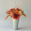 fall flowers with scarecrows in metal vase